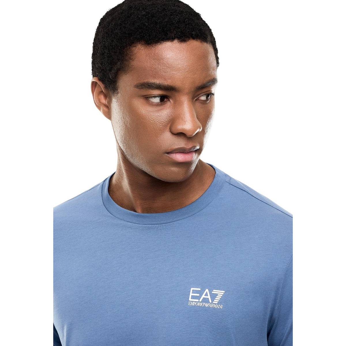 Image 4 : T-shirt sport homme EA7 Emporio Armani col rond bleu porté avec un pantalon marine, look casual — Delvale