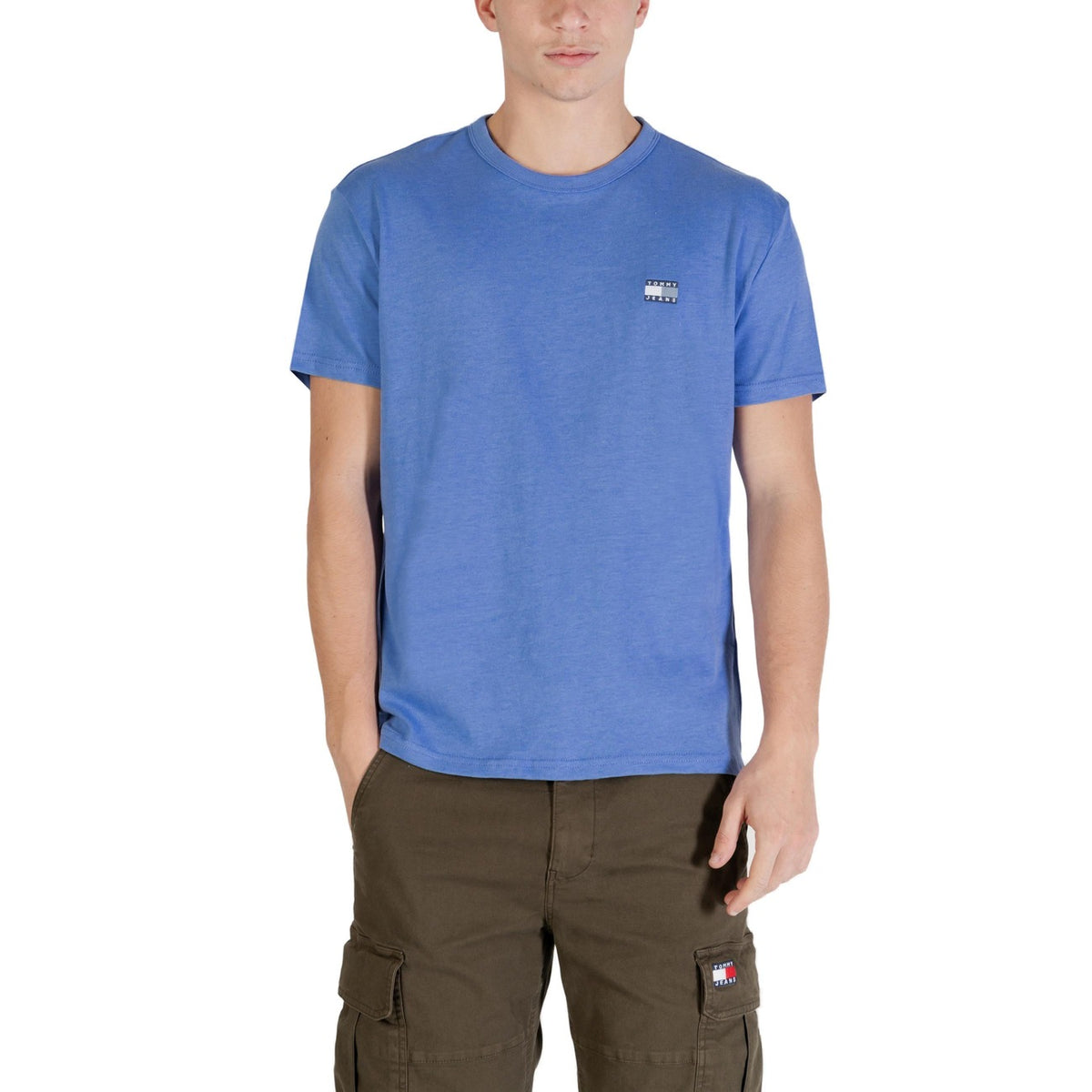 Image 1 : T-shirt Tommy Hilfiger Jeans homme bleu azur col rond avec patch logo poitrine, porté avec un cargo kaki — Delvale