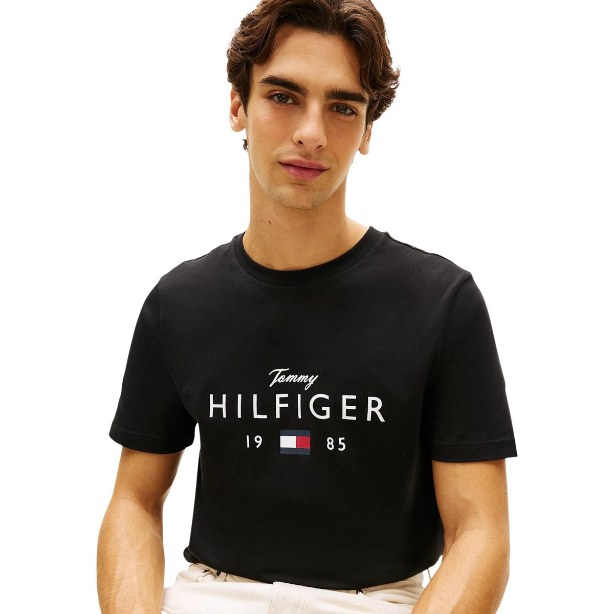 Image 3 : Détail du logo Tommy Hilfiger imprimé sur t-shirt noir homme, inscription Hilfiger et drapeau iconique rouge blanc bleu — Delvale