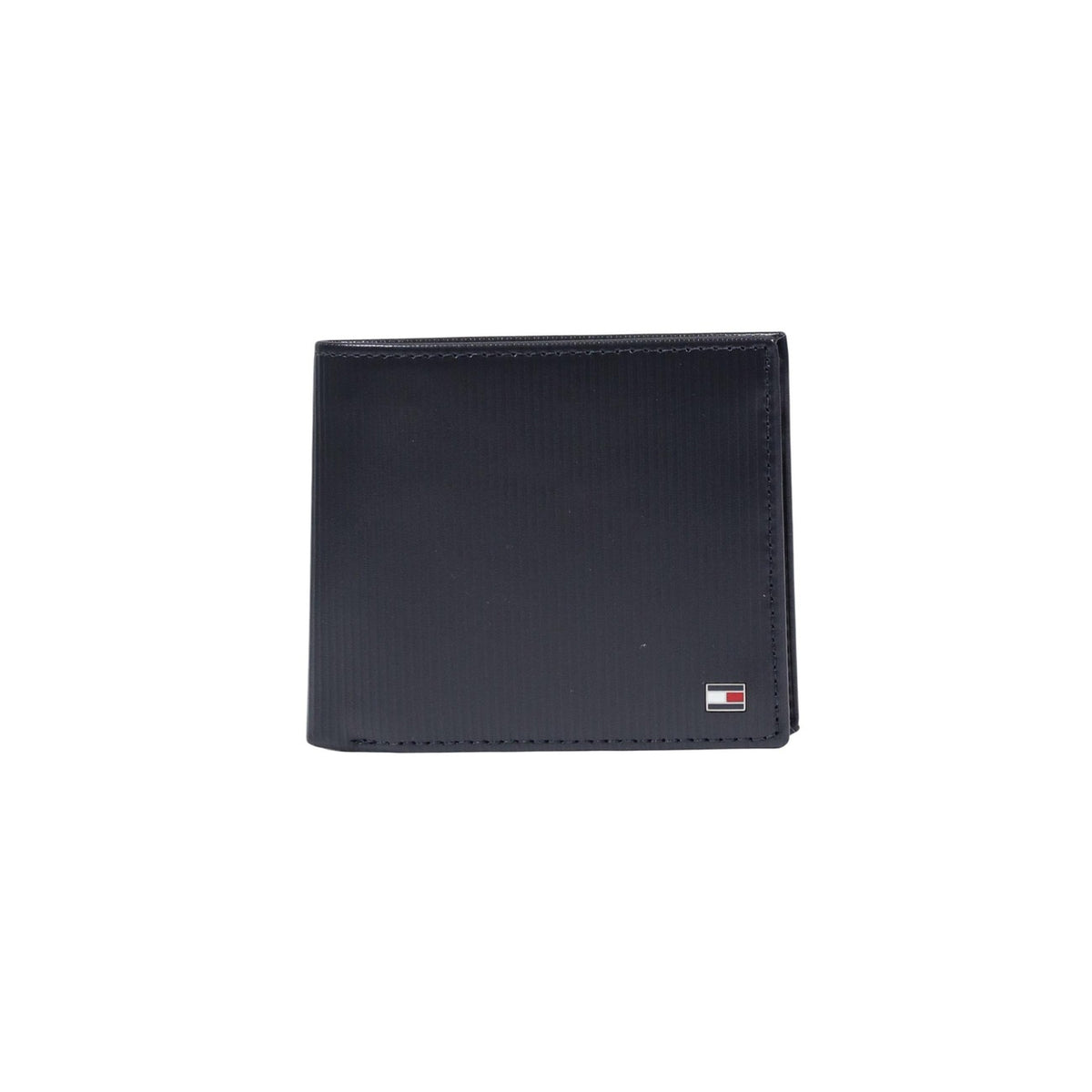 Image 1 : Portefeuille homme Tommy Hilfiger bi-fold en cuir texturé navy avec logo métallique tricolore en coin, fond blanc — Delvale