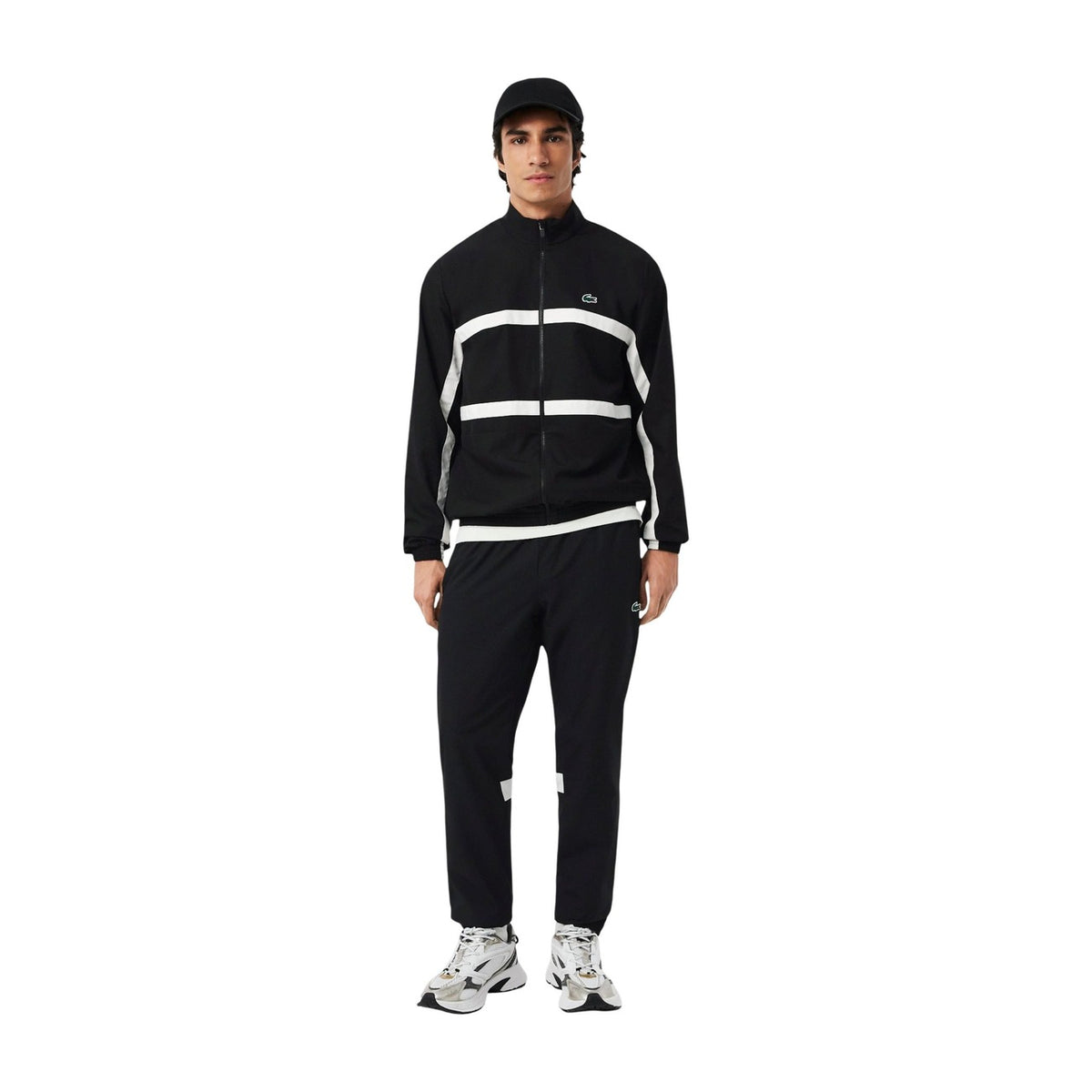 Image 1 : Survêtement Lacoste homme noir avec bandes blanches contrastées, veste zippée col montant et pantalon jogging assortis, vue de face — Delvale