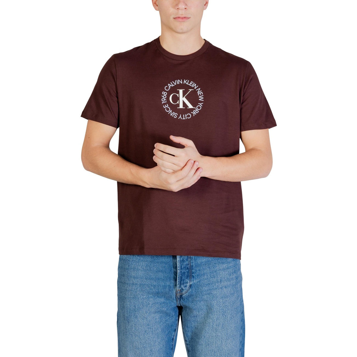 Image 1 : T-shirt homme Calvin Klein Jeans bordeaux avec logo rond CK New York City imprimé en poitrine, porté avec un jean bleu clair — Delvale