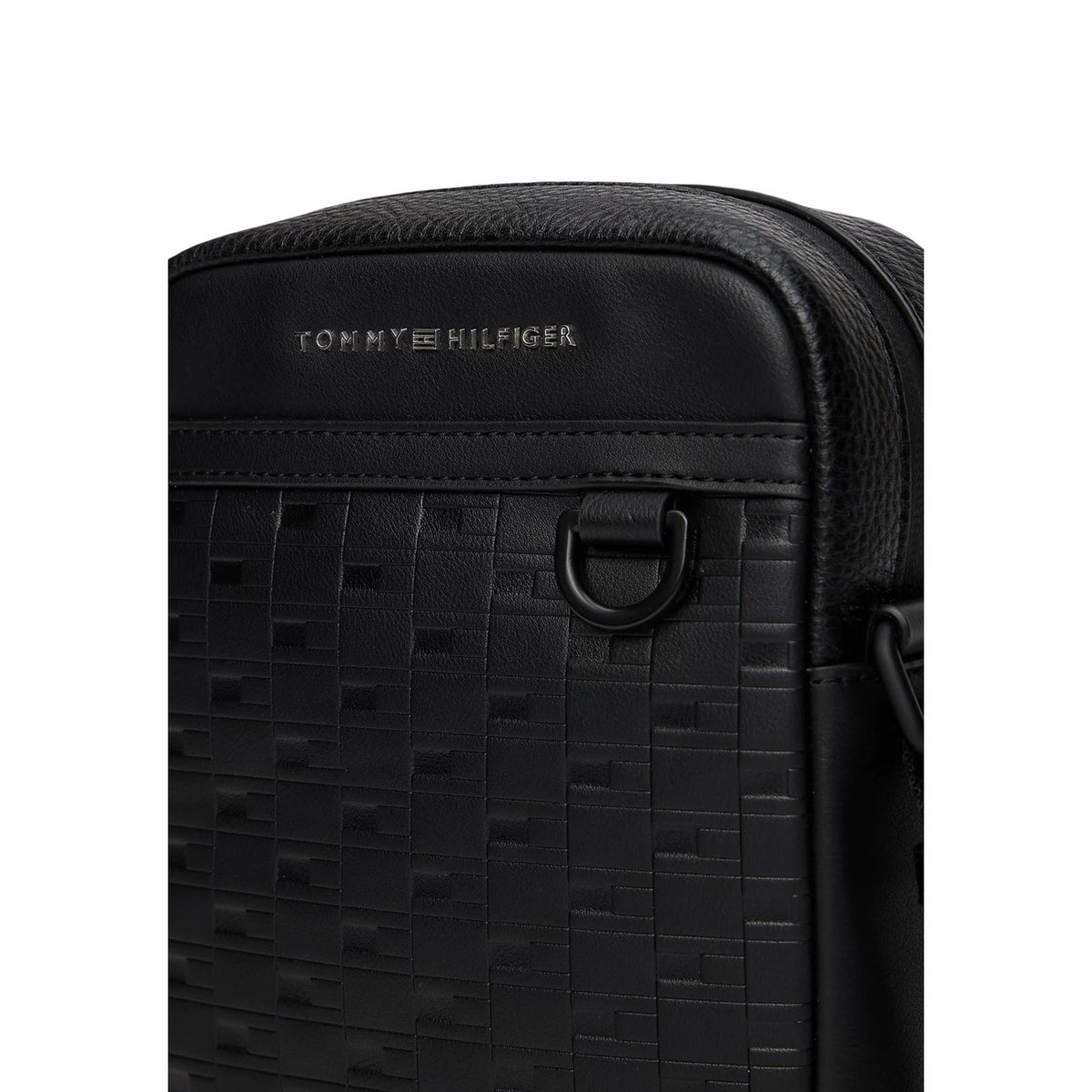 Image 3 : Sacoche Tommy Hilfiger homme noir monogramme TH gaufré relief bande grainée inscription métal sombre gros plan — Delvale