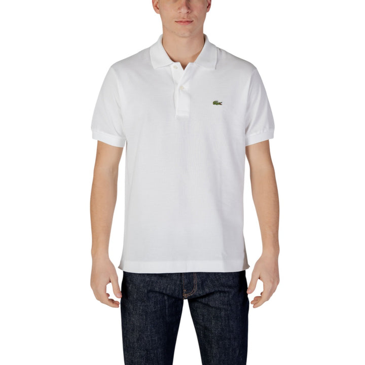 Image 1 : Homme portant un polo Lacoste blanc à manches courtes avec crocodile brodé vert sur la poitrine, associé à un jean brut — Delvale