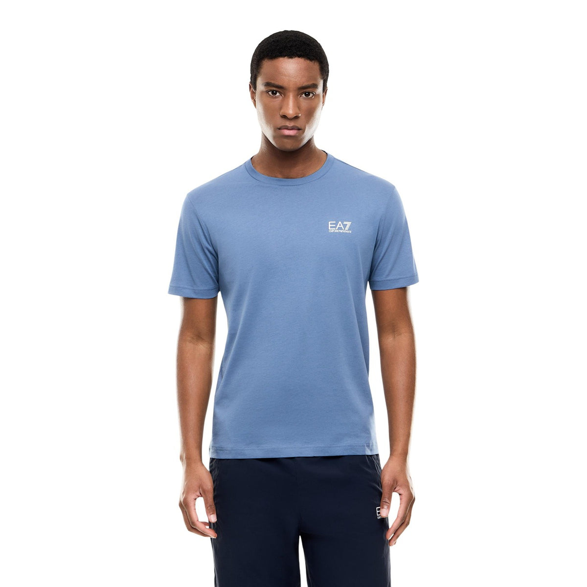 Image 1 : T-shirt EA7 Emporio Armani homme col rond bleu acier avec logo blanc sur la poitrine, porté sur fond blanc — Delvale
