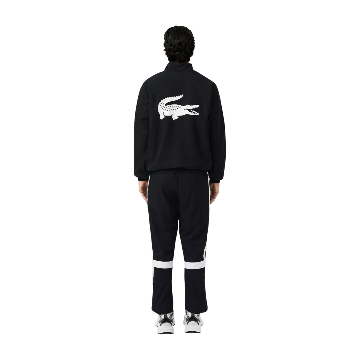 Image 2 : Ensemble jogging Lacoste homme noir, détail des bandes blanches sur la veste et le bas de survêtement, logo crocodile visible — Delvale