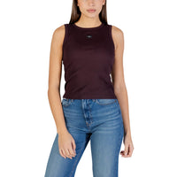 Image 1 : Femme portant un débardeur côtelé bordeaux Calvin Klein Jeans avec badge logo CK centré, associé à un jean brut — Delvale