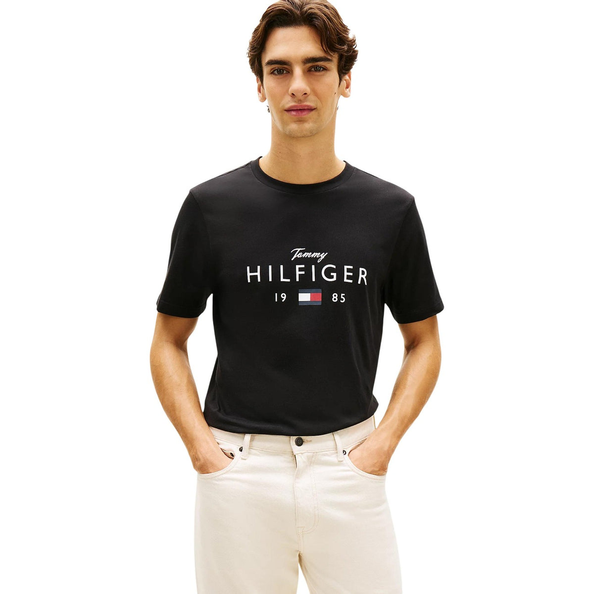 Image 1 : T-shirt noir Tommy Hilfiger Jeans homme avec logo signature imprimé en blanc sur la poitrine, porté par un homme brun sur fond blanc — Delvale