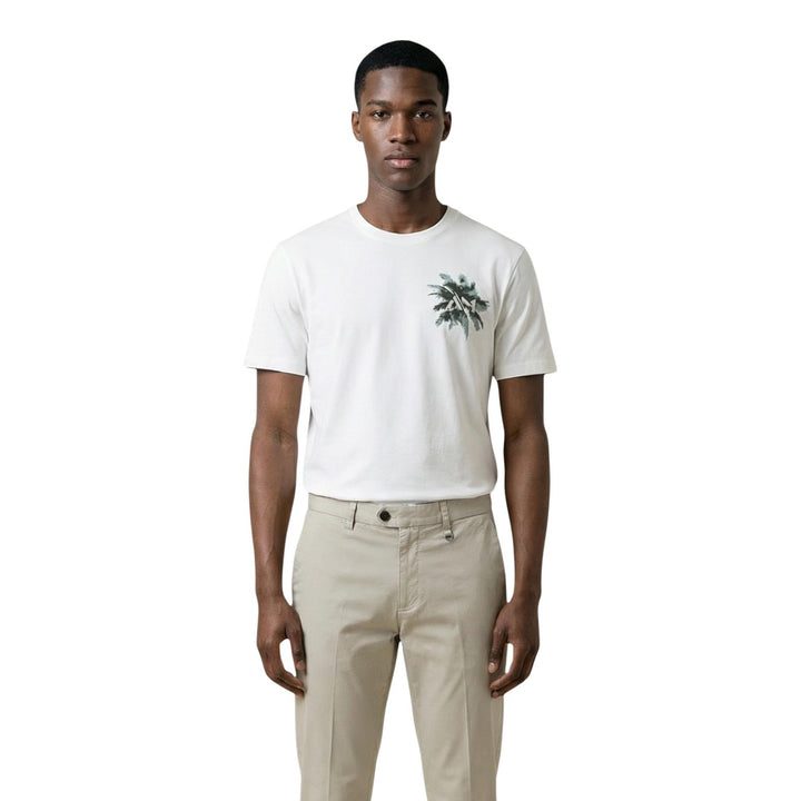 Image 1 : T-shirt homme Antony Morato blanc col rond avec motif palmiers vert sur la poitrine gauche, porté par un mannequin avec un chino beige — 9yvwh4-xt