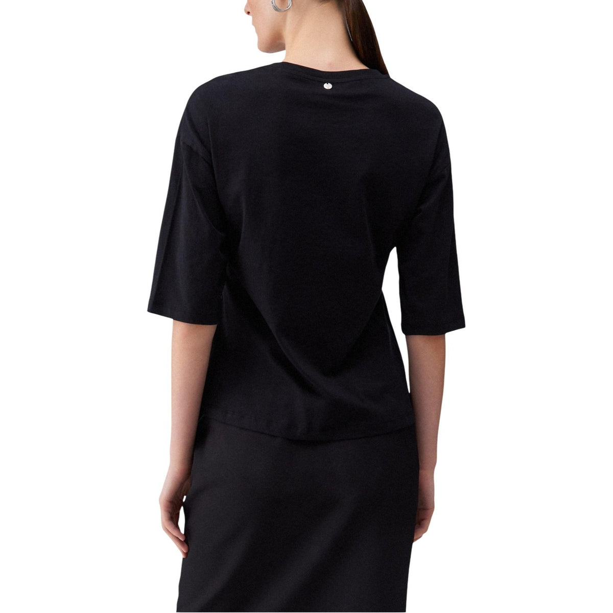 Image 2 : Vue de face du t-shirt Liu Jo noir avec détails strass sur l'encolure, porté avec une ceinture noire clouée et un pantalon noir — Delvale
