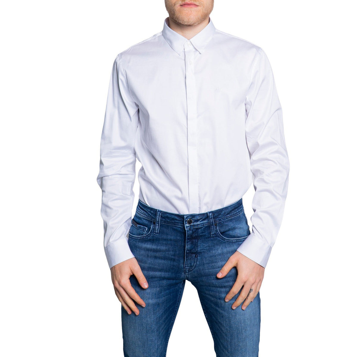 Image 1 : Chemise Armani Exchange homme blanche, col classique, manches longues, portée avec un jean brut, vue de face — Delvale