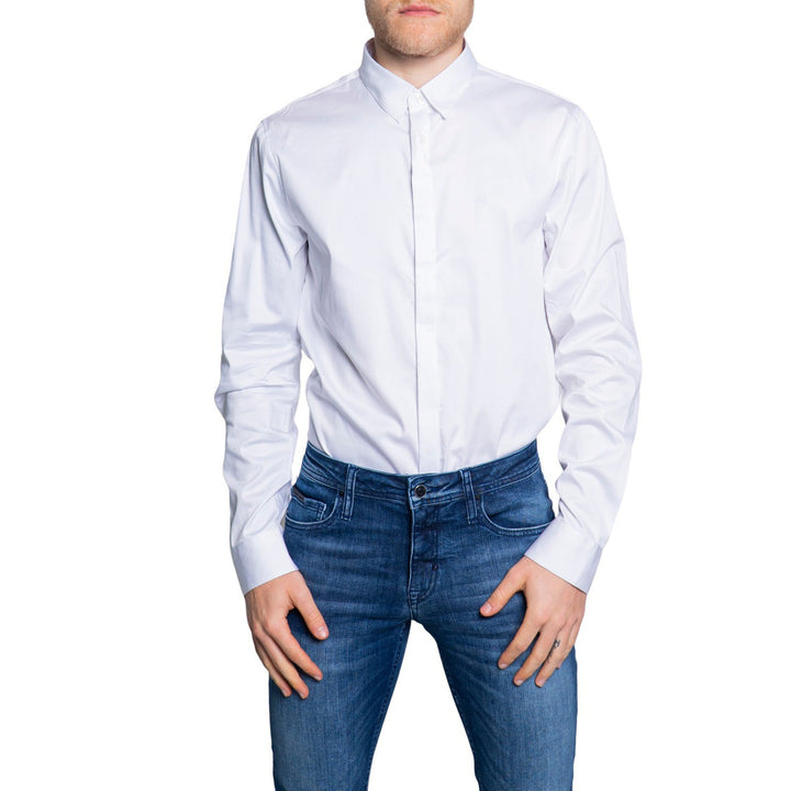 Image 1 : Chemise Armani Exchange homme blanche, col classique, manches longues, portée avec un jean brut, vue de face — Delvale