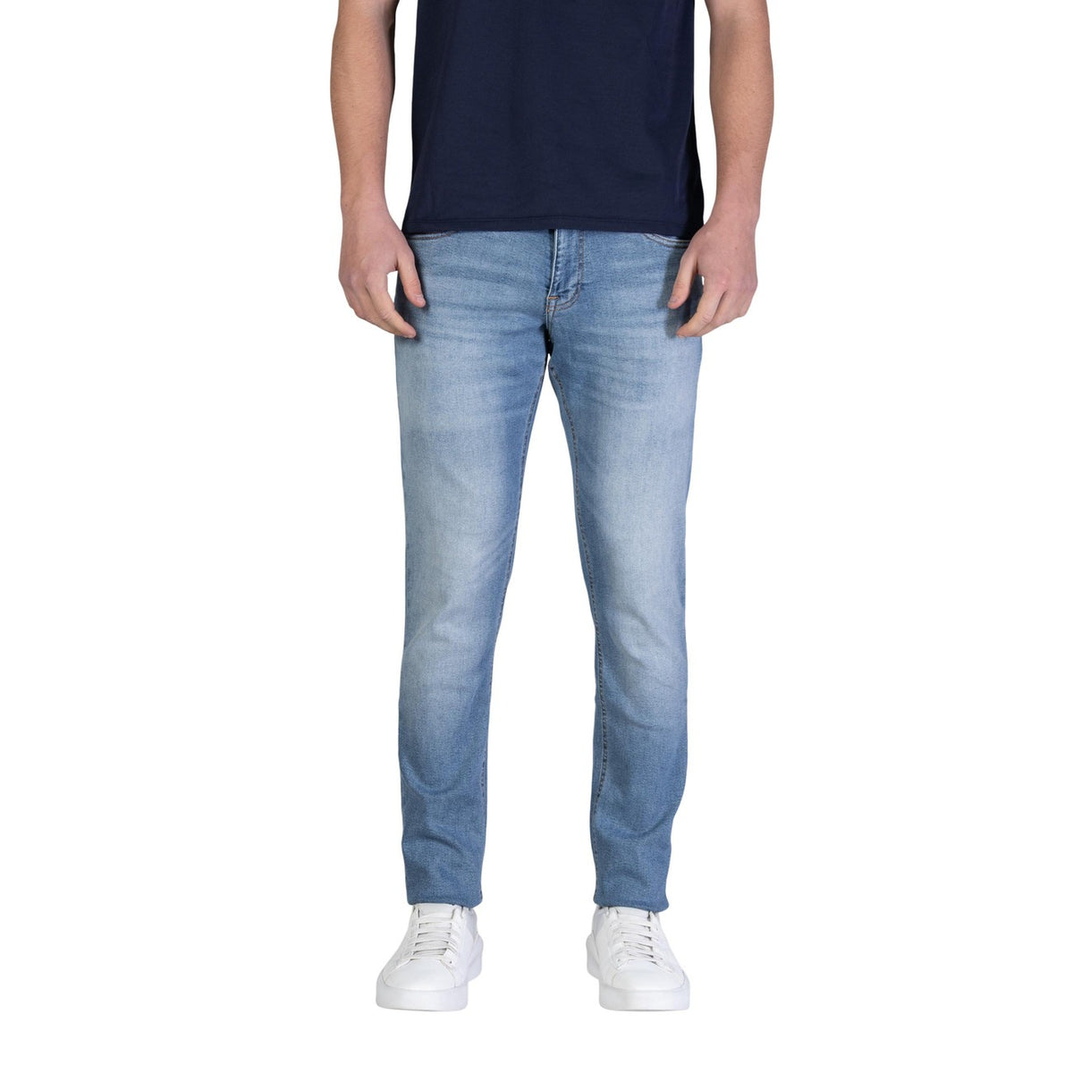 Image 1 : Jean slim stretch Tommy Hilfiger Jeans homme bleu azur délavé, coupe ajustée portée avec t-shirt marine et sneakers blanches, vue de face — Delvale