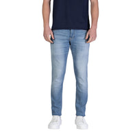 Image 1 : Jean slim stretch Tommy Hilfiger Jeans homme bleu azur délavé, coupe ajustée portée avec t-shirt marine et sneakers blanches, vue de face — Delvale