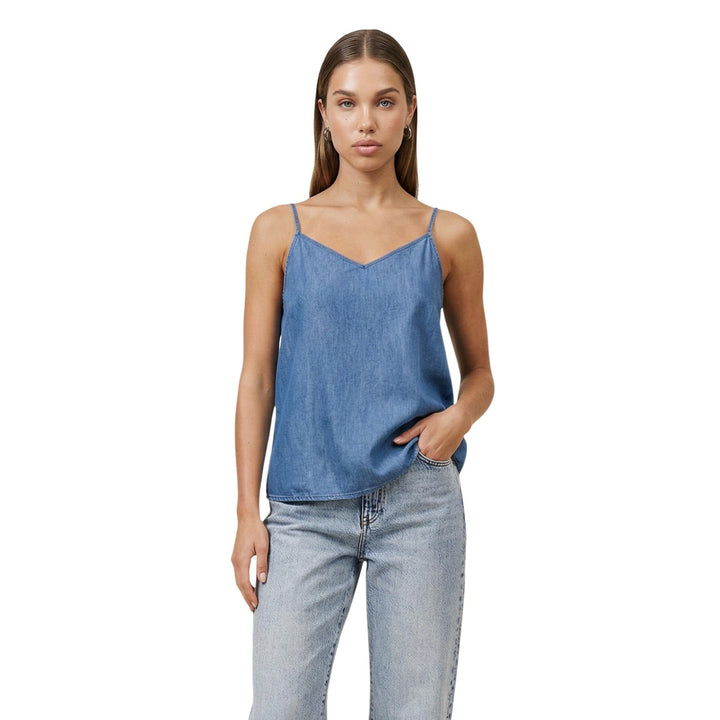 Image 1 : Femme portant un débardeur Only col V effet denim bleu à bretelles fines, associé à un jean délavé clair, fond blanc — Delvale