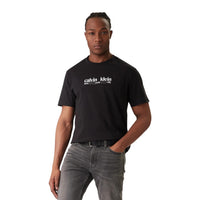 Image 6 : Mannequin masculin aux cheveux bouclés portant un t-shirt Calvin Klein Jeans marron à logo, style modern et iconique — Delvale