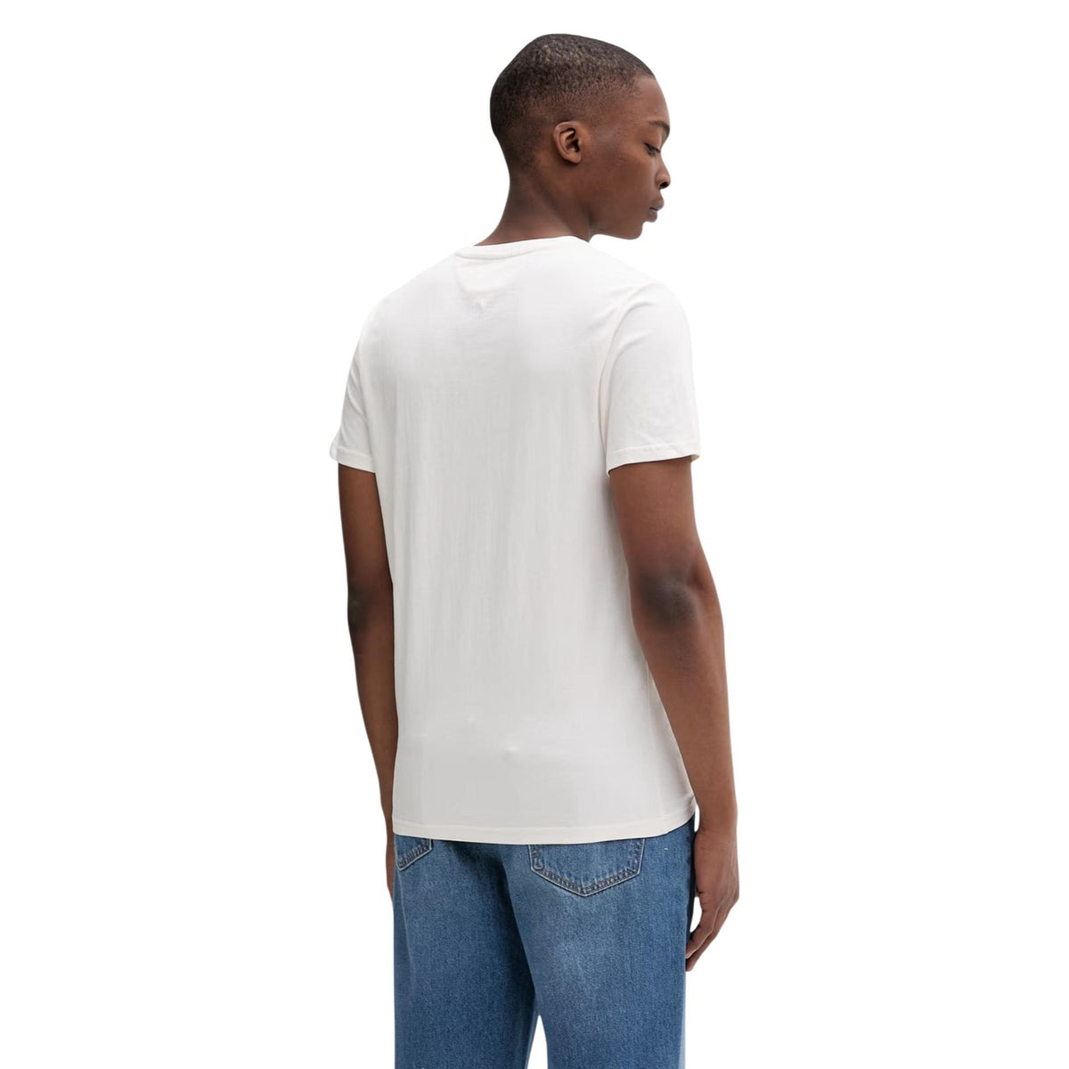Image 3 : Détail du logo flag Tommy Jeans brodé en rouge, blanc et bleu marine sur la poitrine gauche du t-shirt blanc — Delvale