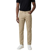 Image 1 : Pantalon chino slim Jeckerson homme coloris beige sable, vue de face portée avec t-shirt noir et sneakers blanches — Delvale