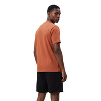 Image 3 : Détail du logo New Balance brodé en blanc sur le t-shirt homme orange terracotta — Delvale