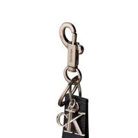 Image 3 : Détail mousqueton métal argenté gravé Calvin Klein et anneau double du porte-clefs cuir noir — Delvale