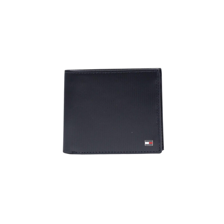 Image 1 : Portefeuille homme Tommy Hilfiger bi-fold en cuir texturé navy avec logo métallique tricolore en coin, fond blanc — Delvale