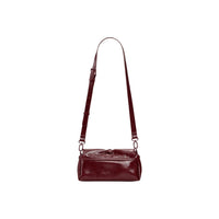 Image 2 : Détail du sac baguette Desigual montrant l'effet verni froissé bordeaux et les finitions caramel — delvale