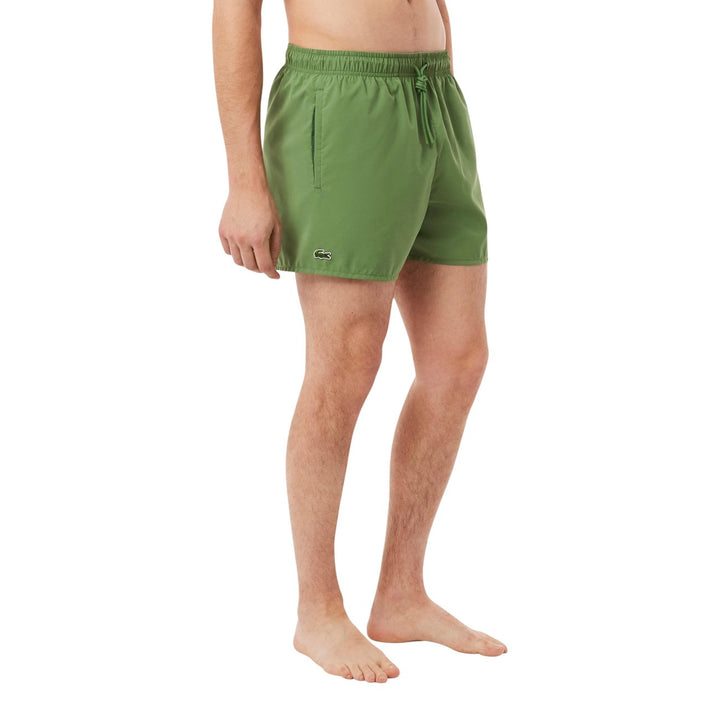 Image 1 : Short de bain Lacoste homme vert uni porté de trois quarts, avec cordon de serrage et logo crocodile brodé sur la hanche — Delvale