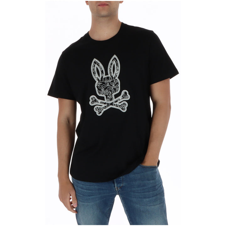 Image 1 : T-shirt Psycho Bunny homme noir avec logo graphique lapin et croix-de-mort imprimé sur le devant, porté avec un jean bleu — Delvale
