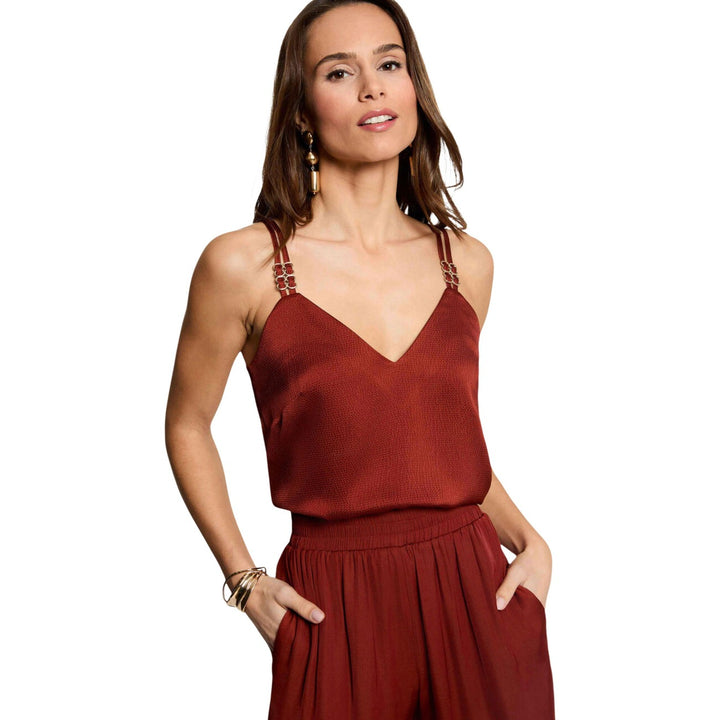 Image 1 : Femme portant un top bordeaux Morgan De Toi col V avec bretelles bijoux dorées, pantalon bordeaux fluide — Delvale
