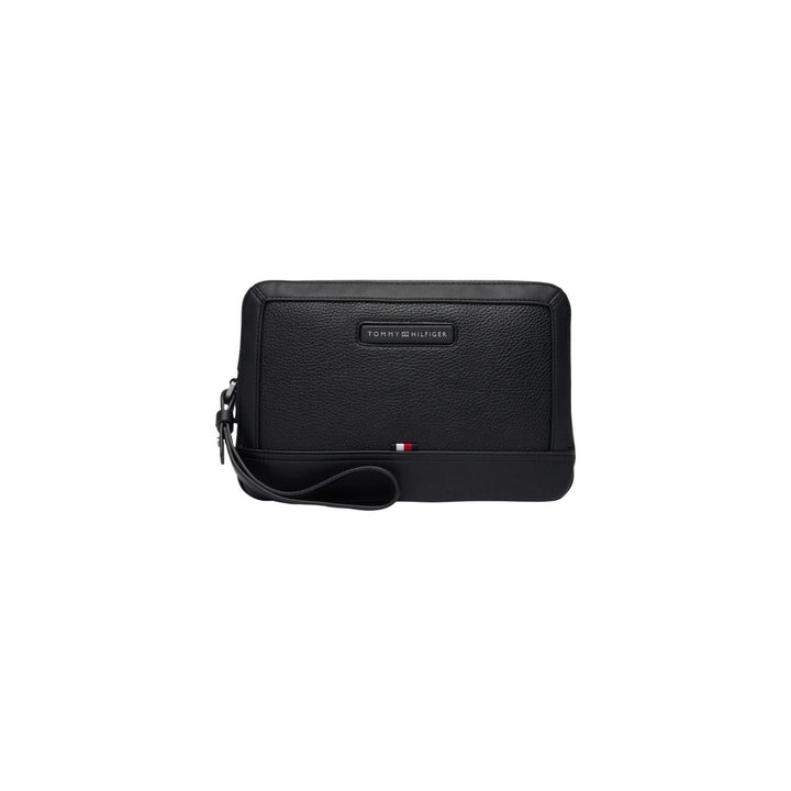 Image 1 : Pochette homme Tommy Hilfiger zippée en cuir grainé noir, vue de face avec badge signature et drapeau tricolore, dragonne de poignet — Delvale