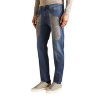 Image 1 : Jean Jeckerson homme bleu moyen avec larges patches en suédine grise sur les cuisses et hanches, coupe droite, porté avec sneakers beiges et pull col roulé crème — Delvale