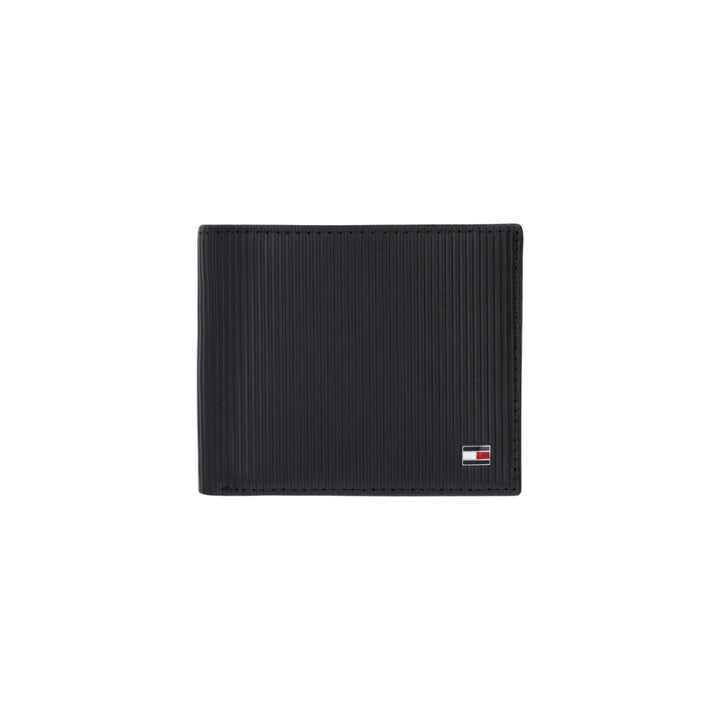 Image 1 : Portefeuille homme Tommy Hilfiger en cuir noir texturé rainures verticales, format bifold slim, plaquette logo métal, fond blanc — Delvale