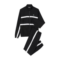 Image 3 : Modèle masculin portant le survêtement Lacoste noir zippé col montant avec baskets blanches, look sport premium — Delvale