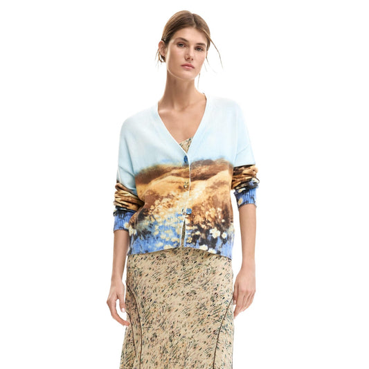 Image 1 : Femme portant le cardigan Desigual à imprimé paysage aquarelle bleu azur et caramel, col en V et boutons dorés, associé à une jupe longue fleurie — Delvale